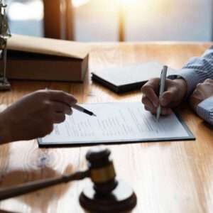 Two people signing legal documents.